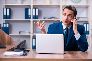 Young handsome businessman working in the office