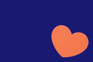 Bright orange heart isolated on a trendy bue background close-up. Top view, copy space. Valentine's Day greeting card
