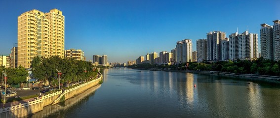 a merged panorama of the East River and residential buildings at both sides in Huizhou, China