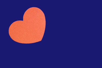 Bright orange heart isolated on a trendy bue background close-up. Top view, copy space. Valentine's Day greeting card