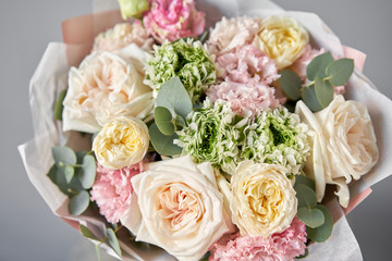 European floral shop. Beautiful bouquet of mixed flowers in glas vase. the work of the florist at a flower shop. Delivery fresh cut flower.