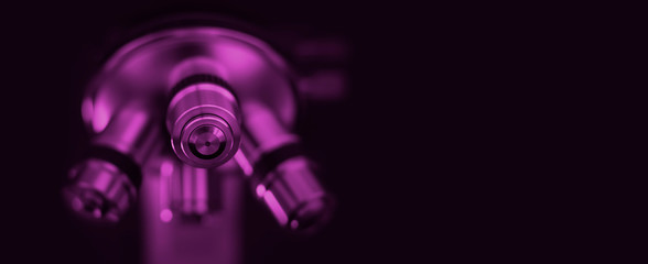 Fototapeta na wymiar Microscope in purple tone. Optical microscope - science and laboratory equipment.