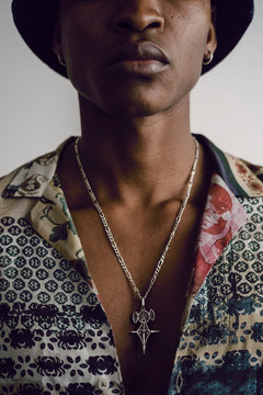 Close up of patterned shirt and necklace on young man's chest
