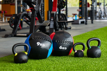 kettlebells of different sizes and different weights are in a row, close-up, gym