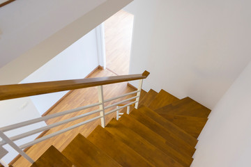 Naklejka premium Wooden stairs in the house, looking down.