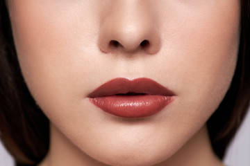 Obraz premium Perfect red lips makeup. Close up macro photo with a beautiful female mouth. Full lips full. Large detail of the face. Perfect clear skin, light fresh lip makeup. 