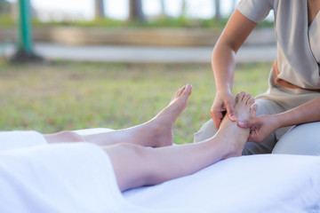 Massage of woman leg in the garden