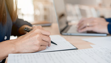 Concept of young business working at his coffee shop and using laptop, holding smartphone in hand discussing the charts and graphs showing the results of their successful teamwork.