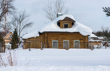 Typical old wooden house covered with snow in the Russian village/ Winter Landscape/ Russia