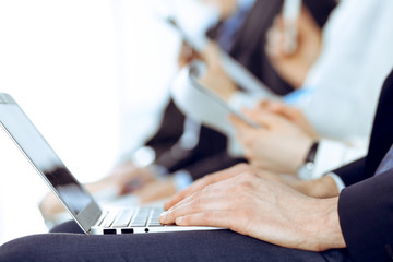 Business people working at meeting or conference, close-up of hands. Group of unknown businessmen and women in modern white office. Teamwork or coaching concept