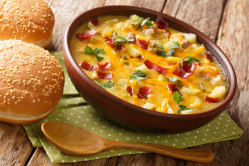 Hearty cheeseburger soup with vegetables, beef, bacon and cheese close-up in a bowl. horizontal