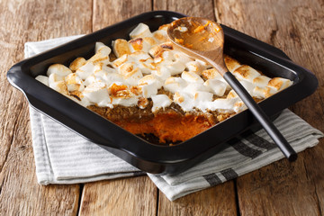American sweet potato casserole with marshmallows close-up in a baking dish. horizontal