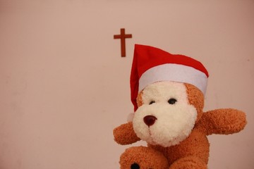 a lovely monkey doll with santa hat and the wooden cross background
