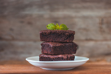 Chocolate brownies stacks on wooden background, homemade sweet and dessert
