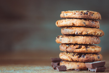 Chocolate chips cookies with crumbs on wooden background, homemade sweet and dessert concept