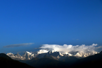 Kanchanjungha during golden hour, snow, peak, landscape, nature, Himalayan. Snowy mountains of Himalaya. A beautiful snowy mountain landscape under a blue cloudy sky..