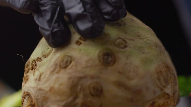 Chef Slicing Fresh Celery Root Close-Up in Professional Kitchen