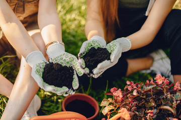 Family works in a garden. Ladies transplants vases