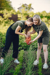 Family works in a garden. Mother with a daughter a pour onion