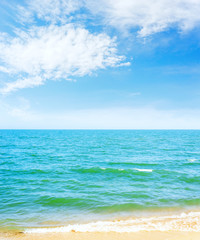 blue sky with clouds over sea and yellow sand