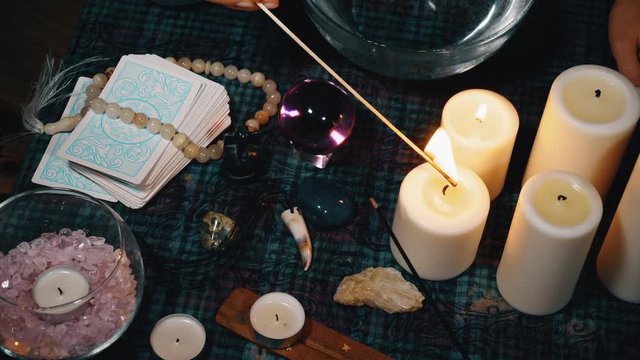 Witch lighting candles with match