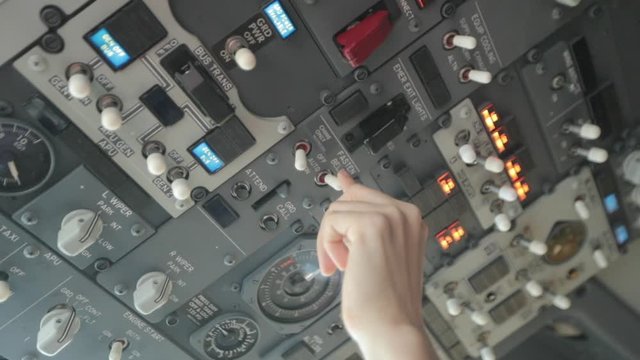Pilot Flipping Switch on Overhead Panel Inside Aircraft