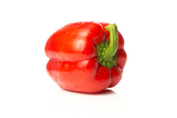 A fresh red pepper is isolated on a white background.
