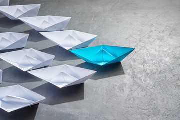 Business Concept, Paper Boat, the key opinion Leader, the concept of influence. One blue paper boat...