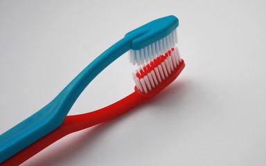 Sex of two tooth brushes. Blue toothbrush lies on the red one. Toothbrushes in love, two persons family concept, dental care.