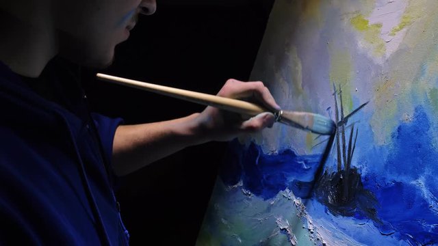Artist copyist paint seascape with ship in ocean. Craftsman decorator draw as boat sail on blue sea with acrylic oil color. Draw finger, brush, knife palette. Indoor. Dark magic cinematic look.