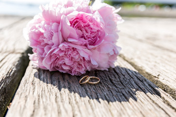 Stillleben mit Eheringen und Brautstrauss in rosa