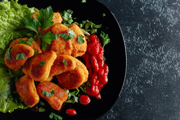  Fried chicken nuggets with ketchup, sprinkled with chopped parsley.