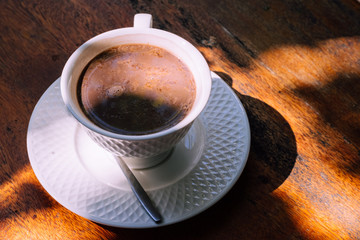 Cup of delicious hot cocoa on brown background, closeup