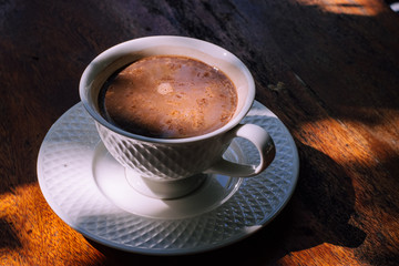 Cup of delicious hot cocoa on brown background, closeup