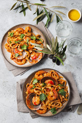 Seafood Spaghetti with seashells, prawns, squids on gray background. Italian mediterranean food concept