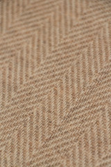 Light beige natural nepalese cashmere fabric. Herringbone tweed, Virgin Wool Background Texture. Expensive material. High resolution. Selective focus.