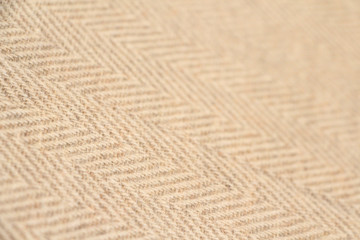 Light beige natural nepalese cashmere fabric. Herringbone tweed, Virgin Wool Background Texture. Expensive material. High resolution. Selective focus.