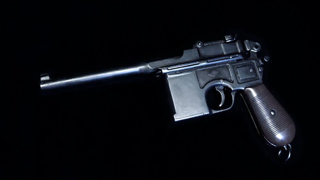 Mauser pistol - a German self-loading pistol, developed in 1895, on a black background. Shot in motion. Macro. Closeup