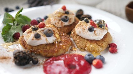 Pouring Honey On Curd Fritters, Syrniki Pancakes For Breakfast. Closeup.