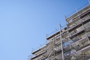 Scaffolding installed on a residential building for the restoration of the facade. Text space