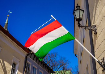 Hungarian flag on building against blue sky on bright Sunny day