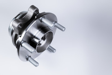 New Wheel hub assembly with bearing. This is part of the car suspension on a gray background with a gradient. The concept of new car parts