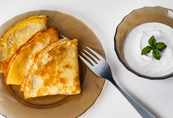 pancakes with sour cream on a plate