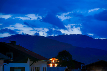 Rot Beleuchtete Hütte umrahmt von dunklen Bergen im Hintergrund - Blauestunde Sonnenuntergang