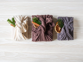 Eco-friendly fabric reusable gifts packaging with fir brunch, cinnamon stick and dry orange slice. Christmas reusable sustainable gift wrapping alternative. Zero waste concept. Copy space
