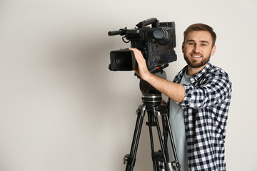 Operator with professional video camera on white background