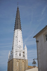 Fototapeta premium Church of Ars with black and white bell tower in the Ile de Re in Charente France