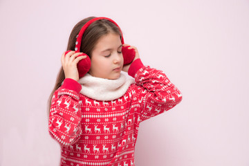 Girl wearing a Christmas pullower, a warm scarf and fur headphones