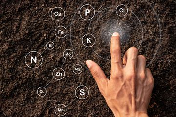 The hands of men are touching on the soil where abundance and technology are icons about the...