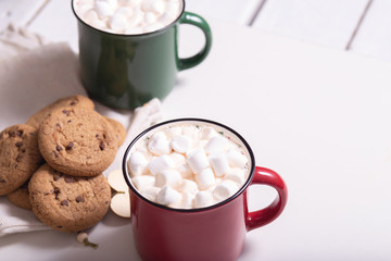 Red mug with cocoa and marshmallows and homemade cookies with chocolate, wooden heart - Christmas tree toy on a light background